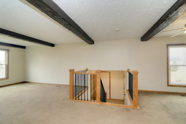 en empty room with windows and ceiling fan