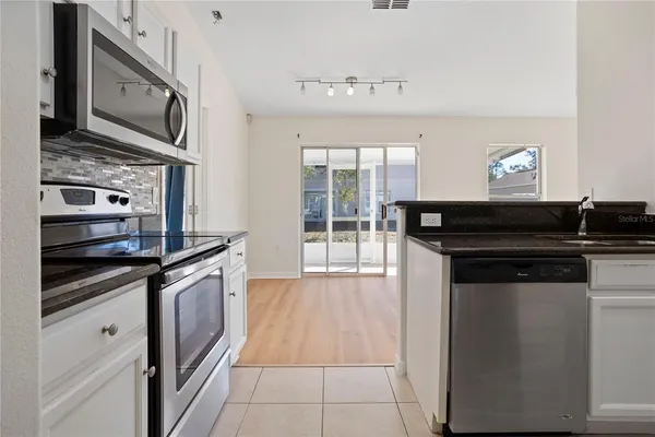 a kitchen with granite countertop a stove and a microwave