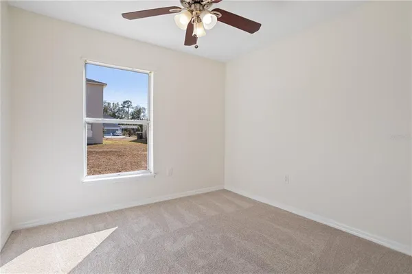 an empty room with a window and a fan
