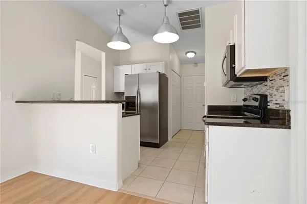 a kitchen with stainless steel appliances a refrigerator a sink a stove a microwave and island