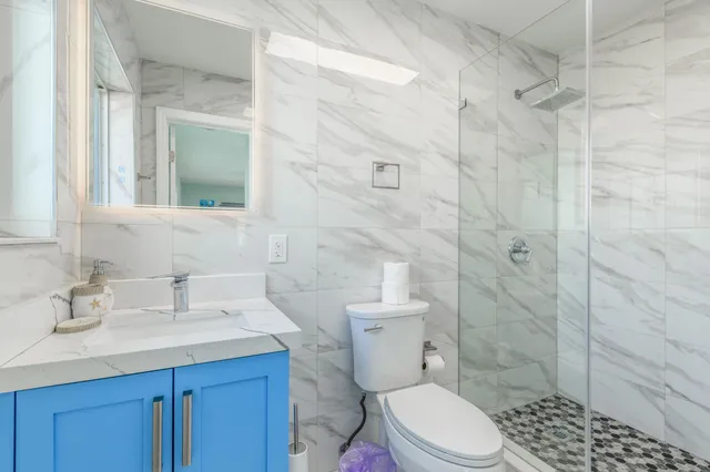 a bathroom with a sink a toilet and shower