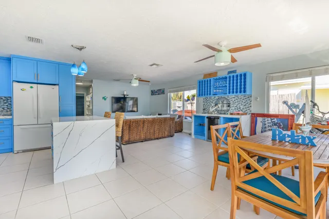 a kitchen with stainless steel appliances kitchen island granite countertop a refrigerator a stove a sink dishwasher and a dining table with the kitchen view