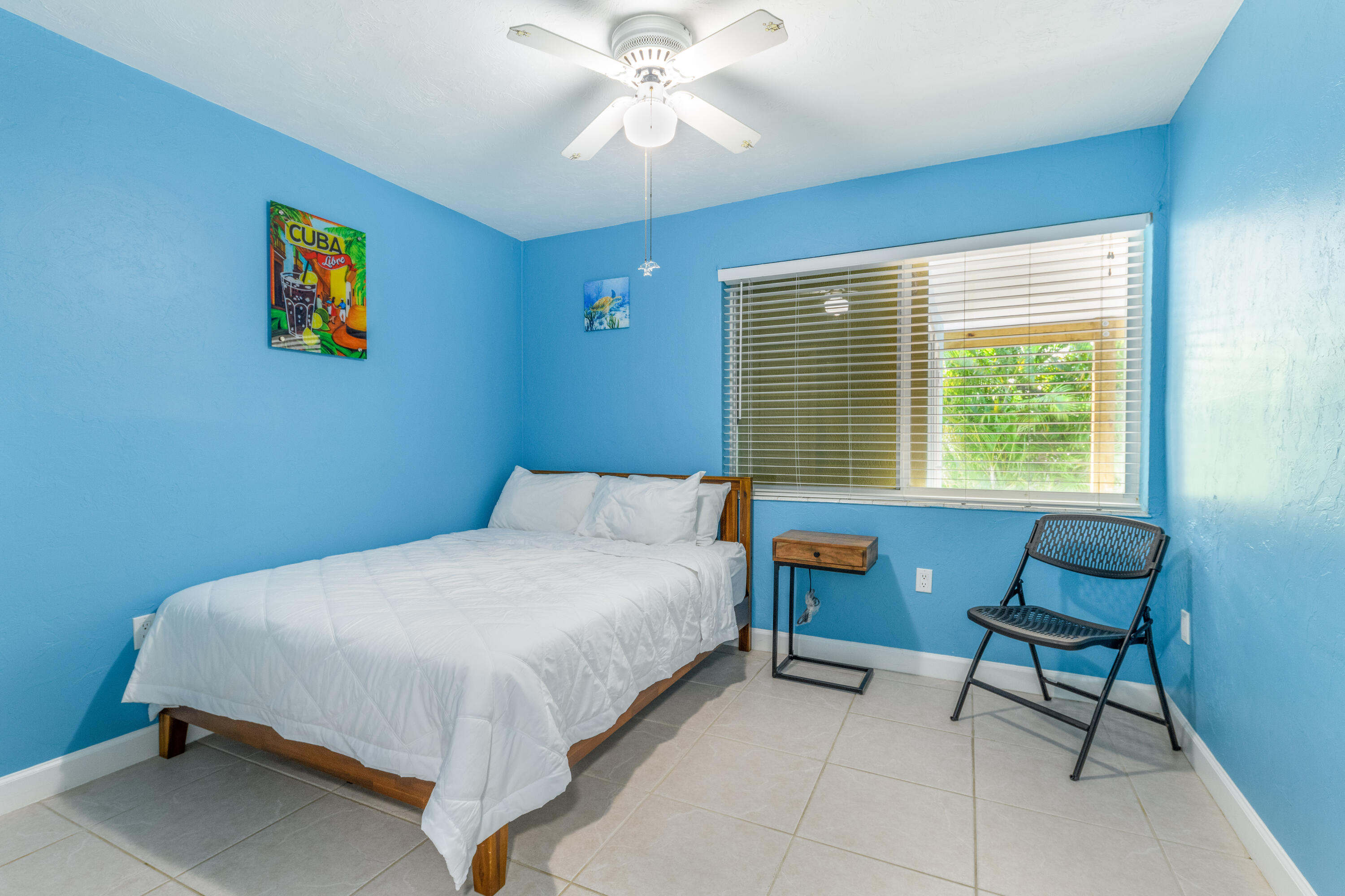 8260 Aviation Boulevard Marathon, FL 33050 - Photo 21 of 36 a bedroom with a bed a chair and a large window