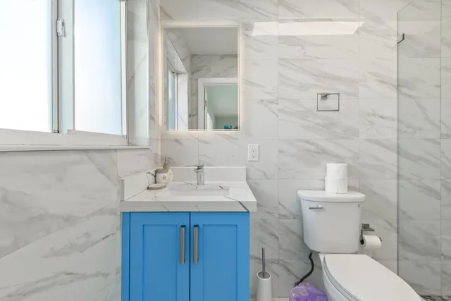 a bathroom with a toilet sink and mirror