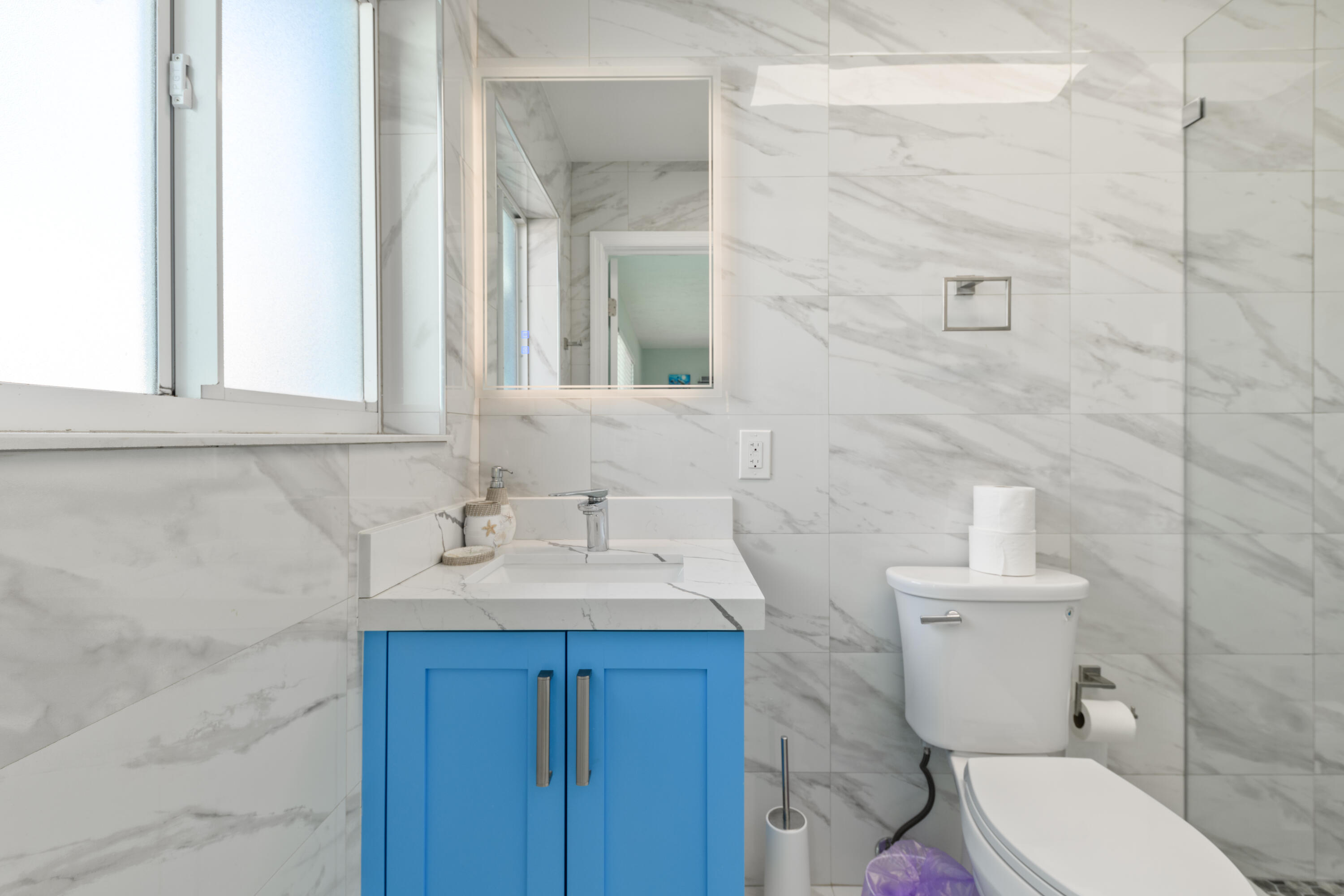 8260 Aviation Boulevard Marathon, FL 33050 - Photo 10 of 36 a bathroom with a toilet sink and mirror