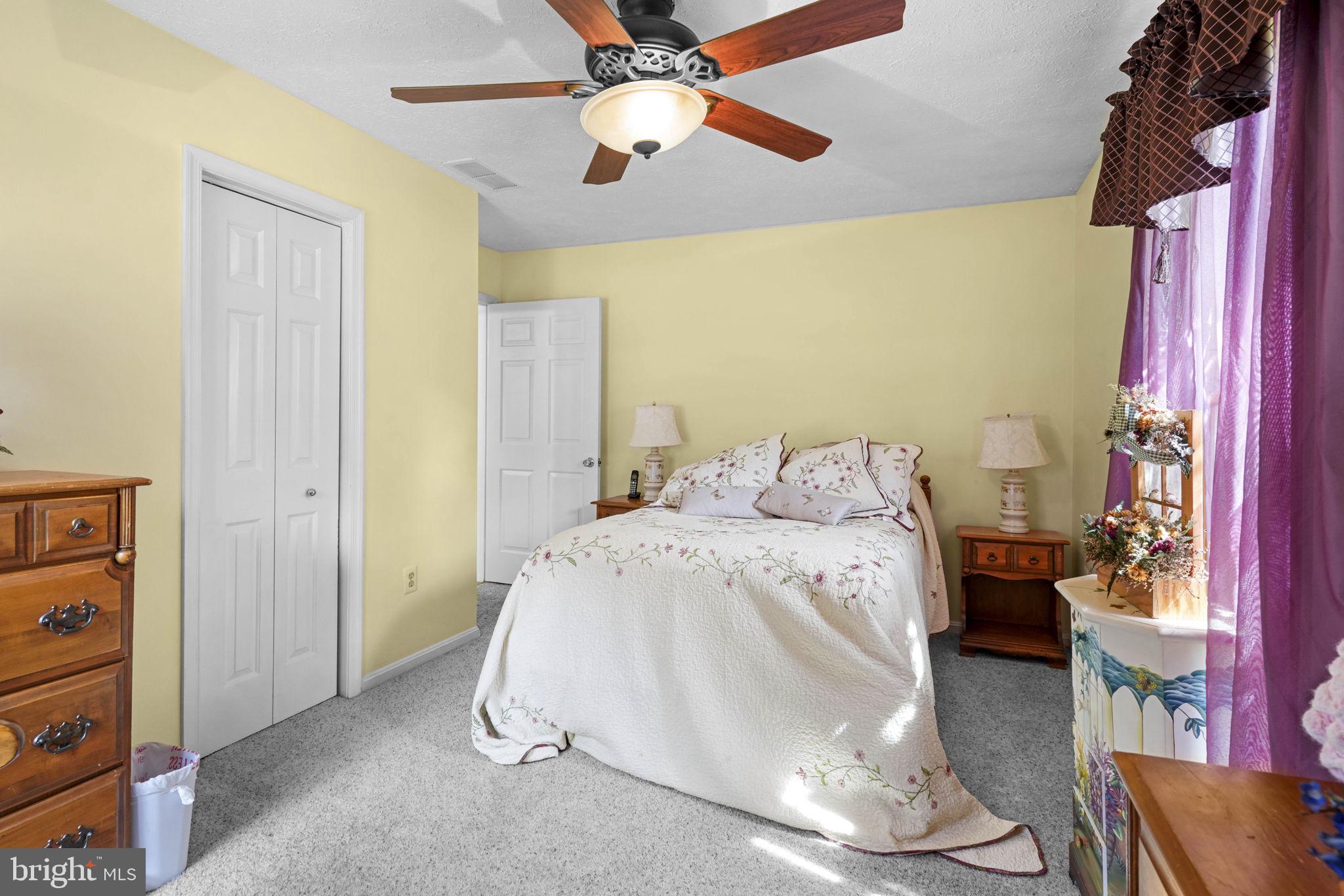 4949 Idlewilde Road Shady Side, MD 20764 - Photo 19 of 28 a spacious bedroom with a bed and a chandelier