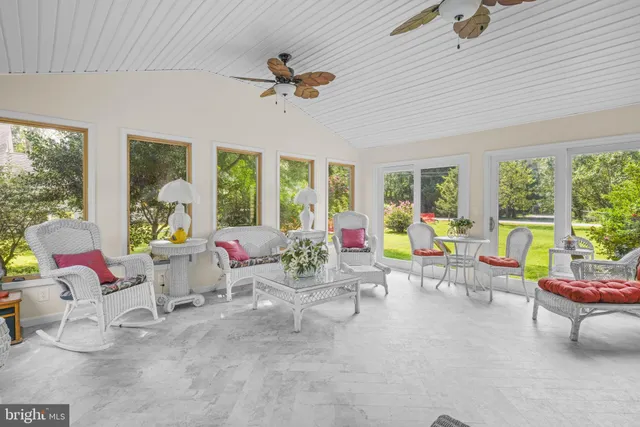 a living room filled with furniture and floor to ceiling windows