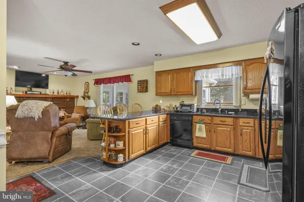 a large white open kitchen with stainless steel appliances granite countertop a stove and a sink