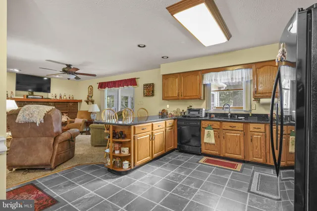a large white open kitchen with stainless steel appliances granite countertop a stove and a sink