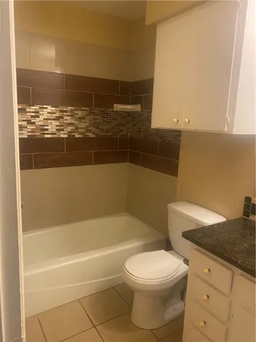 a bathroom with a granite countertop sink and a window