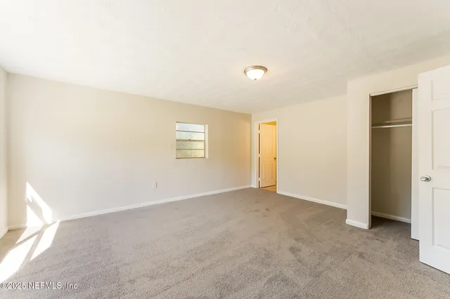 an empty room with windows and closet