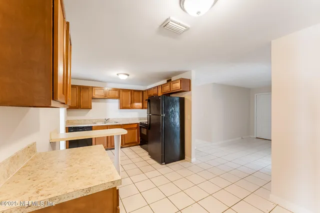 a kitchen with a refrigerator and a stove top oven