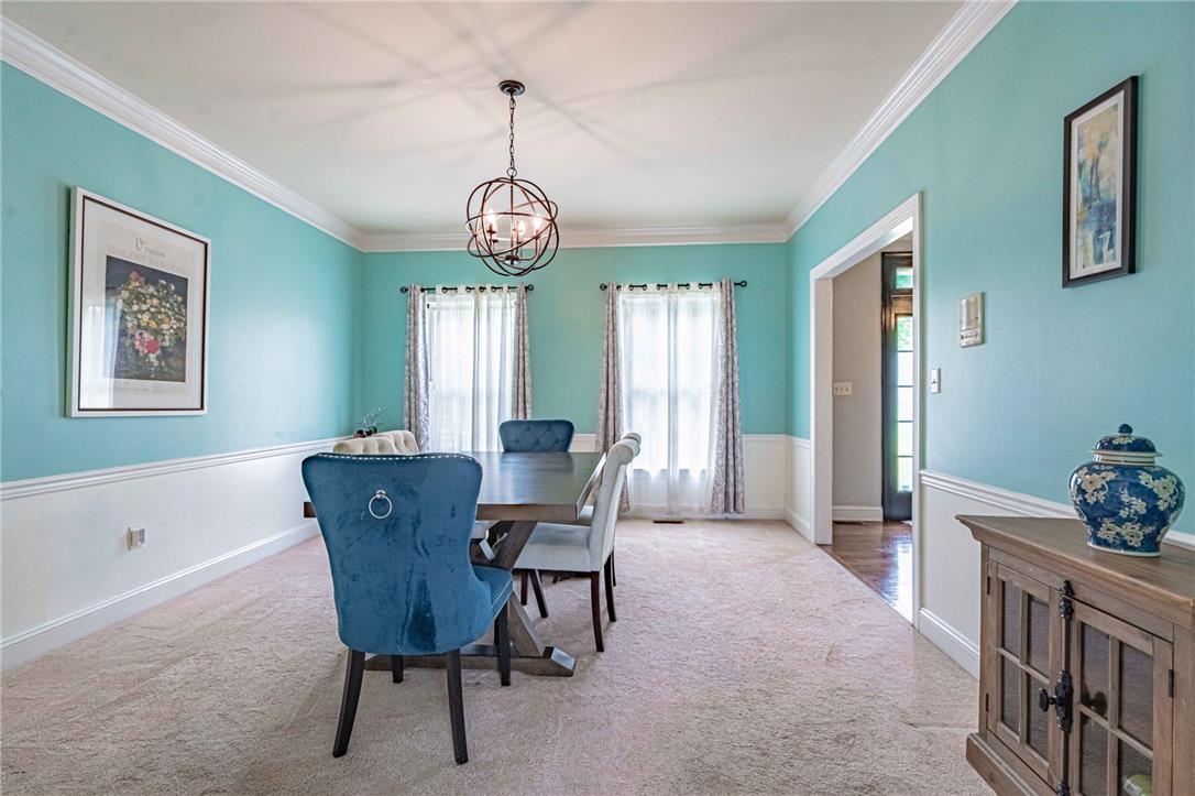 102 Sutton Road Easton, PA 18045 - Photo 17 of 83 Elegant crown molding frames this formal dining room featuring wainscoting and plush carpeting.