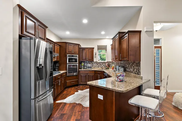 a kitchen with stainless steel appliances granite countertop a sink stove and cabinets