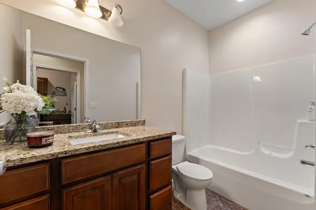 a bathroom with a granite countertop sink a large mirror and a vanity