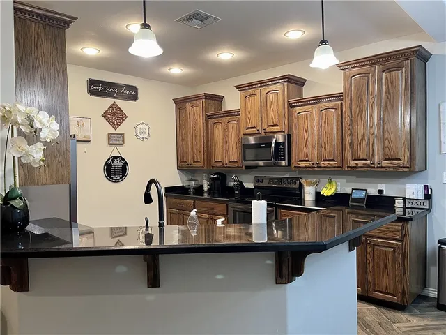 a kitchen with stainless steel appliances granite countertop a refrigerator and a sink