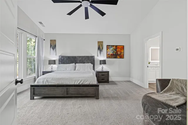 a spacious bedroom with a bed couch and window