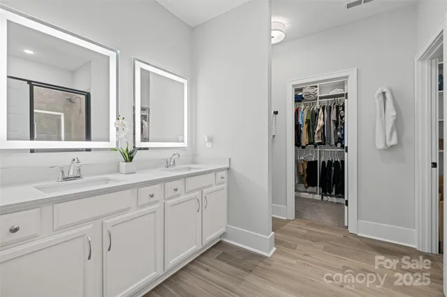 a spacious bathroom with a double vanity sink and mirror