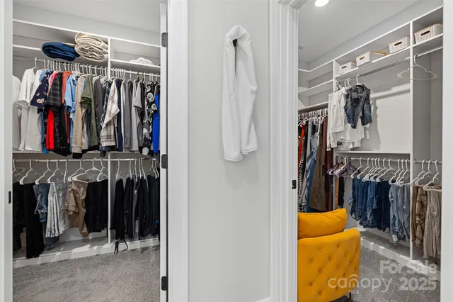 a view of walk in closet with clothes