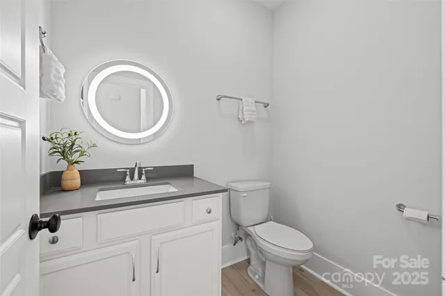a bathroom with a granite countertop toilet a mirror and a sink