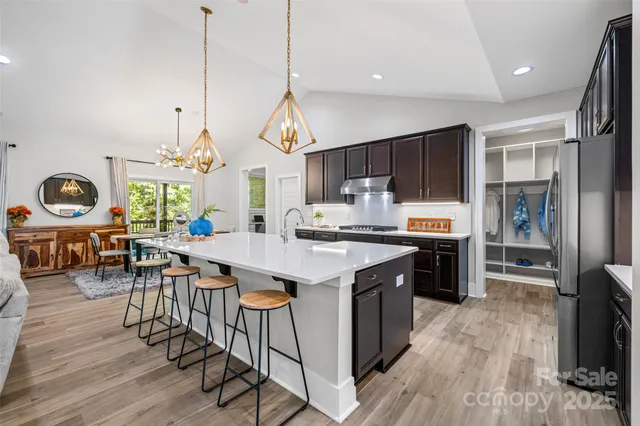 a kitchen with granite countertop a stove a sink a oven and a refrigerator
