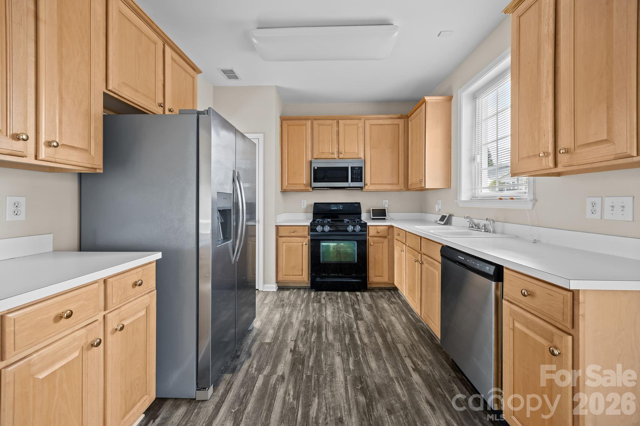 3203 Arklow Road Charlotte, NC 28269 - Photo 10 of 44 a kitchen with granite countertop wooden floors stainless steel appliances a sink and a window