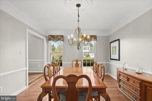 a kitchen with stainless steel appliances granite countertop a stove top oven a dining table and chairs with wooden floor