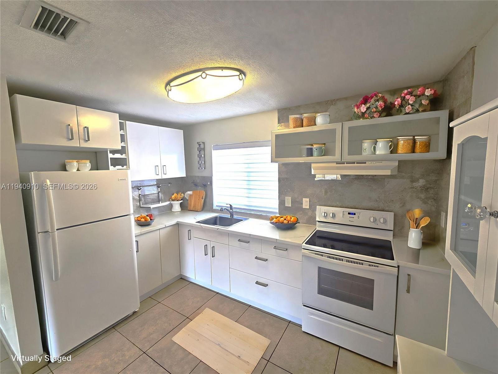 2775 West 61st Street, Unit 203 Hialeah, FL 33016 - Photo 6 of 8 a kitchen with a refrigerator and a sink