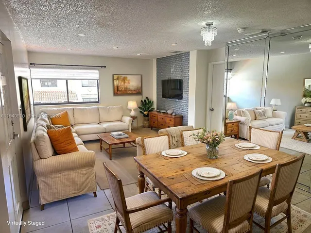 a living room with furniture kitchen view and a wooden floor
