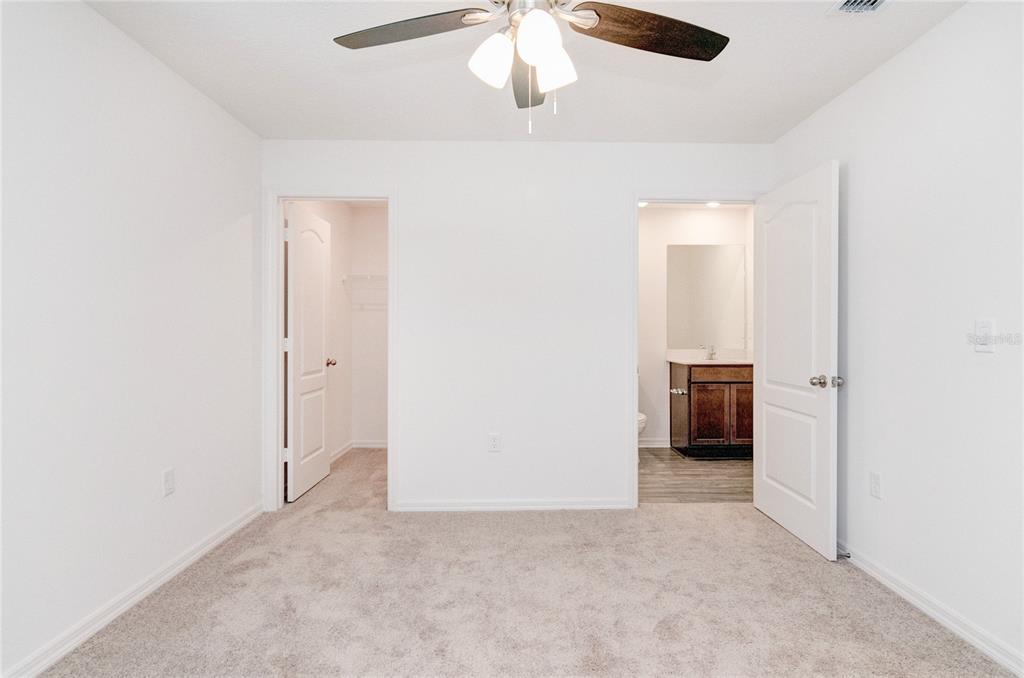 1668 Wynford Circle Tavares, FL 32778 - Photo 18 of 30 an empty room with a ceiling fan and kitchen view