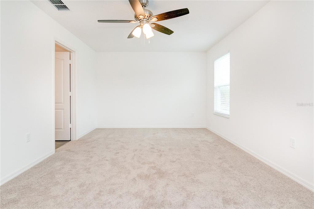 1668 Wynford Circle Tavares, FL 32778 - Photo 22 of 30 an empty room with windows and fan