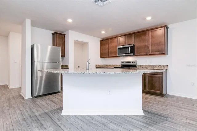 a kitchen with granite countertop a sink stove and cabinets
