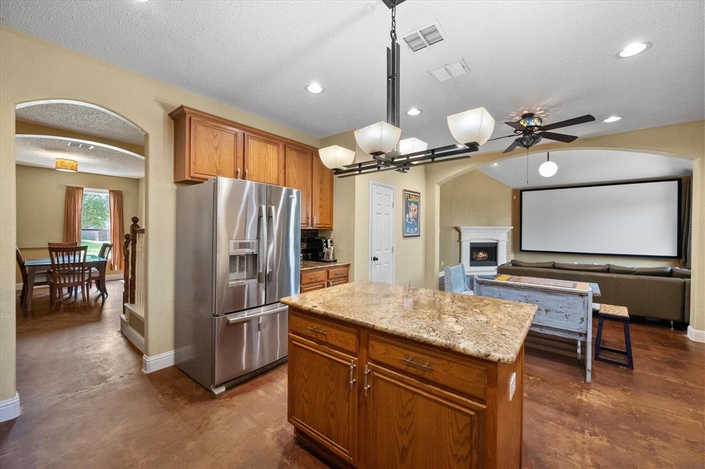 1305 Liverpool Lane Mansfield, TX 76063 - Photo 24 of 40 The kitchen features a granite-topped island, wood cabinetry, and stainless steel appliances