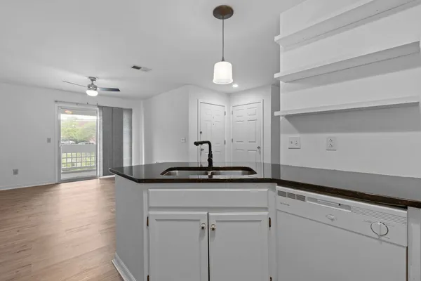 a kitchen with stainless steel appliances granite countertop a sink and dishwasher with wooden floor