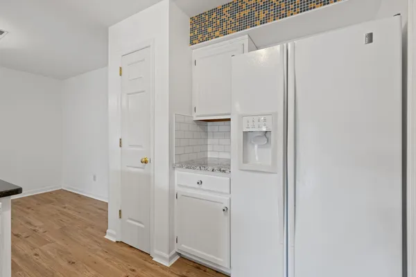 a living room with stainless steel appliances kitchen island granite countertop wooden floor and a view of living room