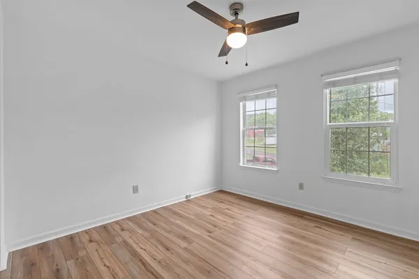 a view of an empty room with wooden floor
