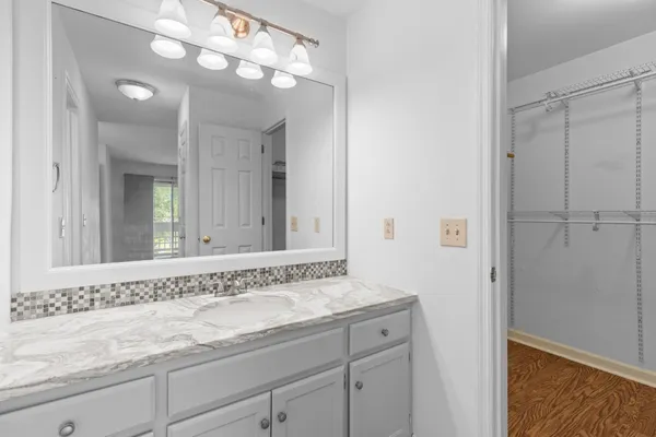 a bathroom with a granite countertop sink a toilet and a mirror