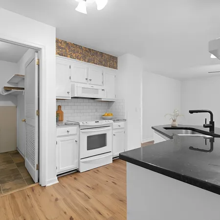 a kitchen with white cabinets and white appliances