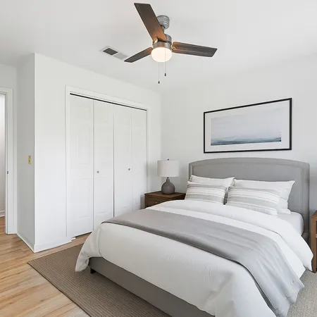 a bedroom with a large bed and a ceiling fan