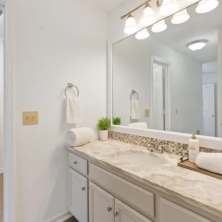 a bathroom with a granite countertop sink and a mirror