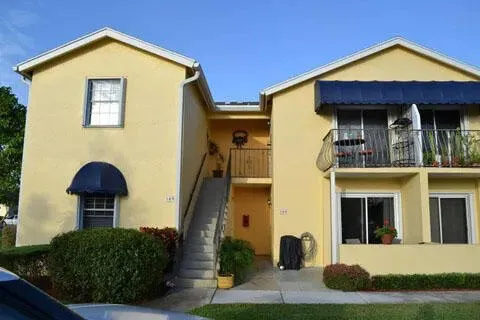 a view of a house with many windows and plants