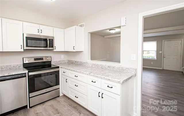 a kitchen with stainless steel appliances granite countertop a stove microwave and sink