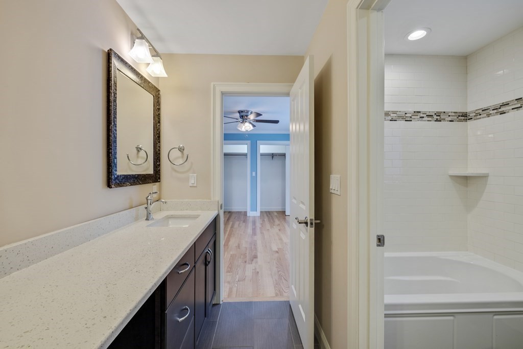 27 Webster Road Lexington, MA 02421 - Photo 34 of 42 a bathroom with a granite countertop sink mirror and a bathtub
