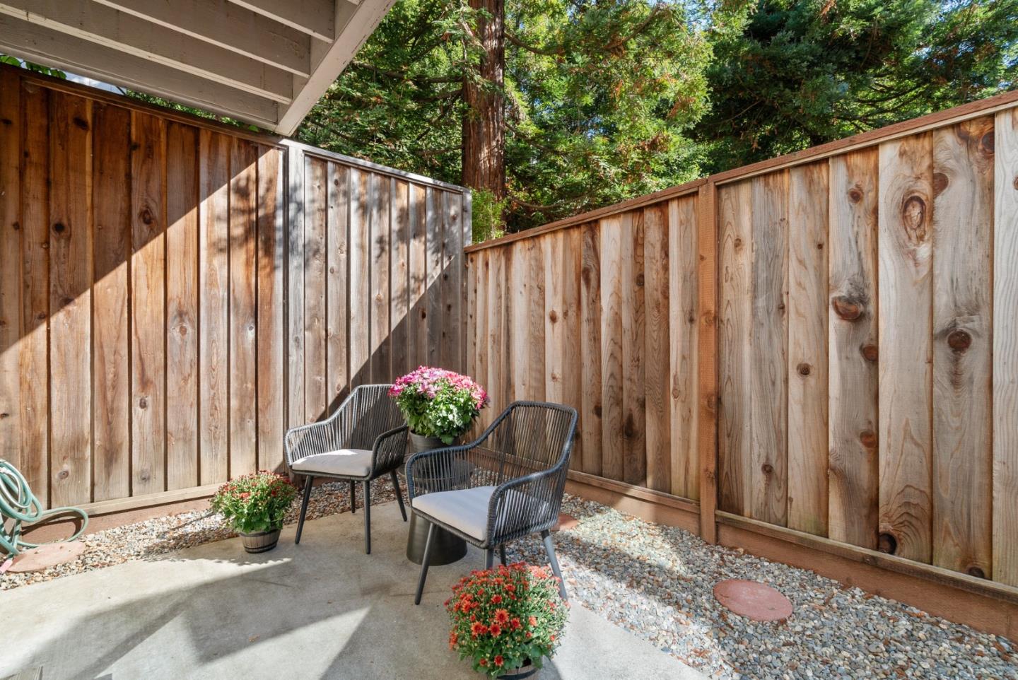 355 Village Creek Road Aptos, CA 95003 - Photo 26 of 41 a backyard of a house with table and chairs wooden fence and plants