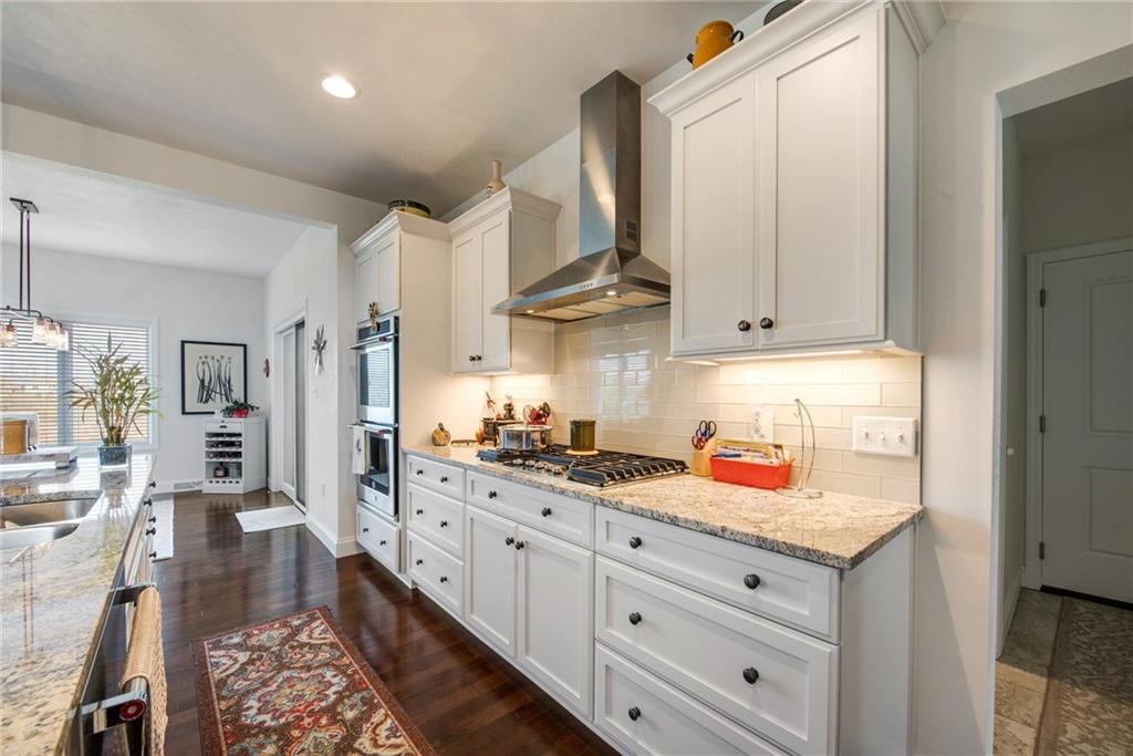 7372 Sierra Drive Irwin, PA 15642 - Photo 9 of 32 a kitchen with stainless steel appliances granite countertop a lot of counter space and wooden floors