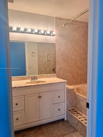 a bathroom with a granite countertop sink and a mirror