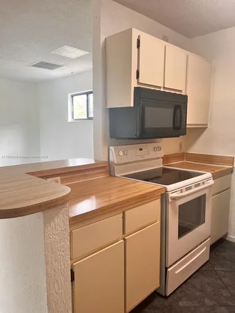 a kitchen with appliances a sink and cabinets