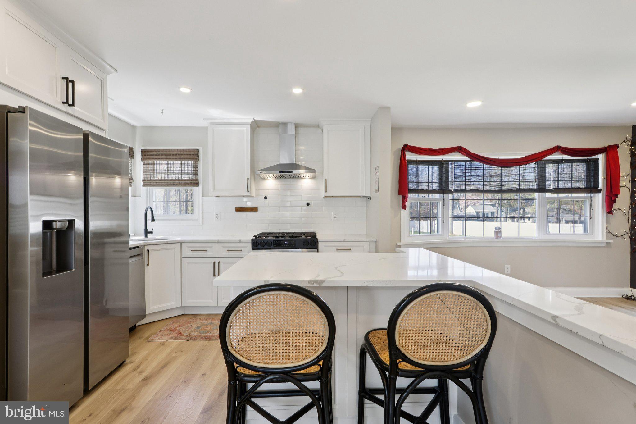 351 Merrick Road Robbinsville, NJ 08691 - Photo 24 of 69 a kitchen with stainless steel appliances granite countertop a refrigerator a stove a sink and a dining table with wooden cabinet