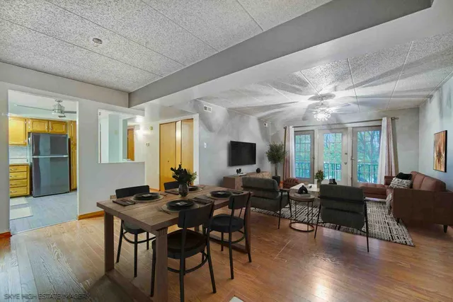 a living room with furniture a wooden floor and a large window