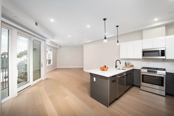 a kitchen with kitchen island stainless steel appliances a stove sink and cabinets